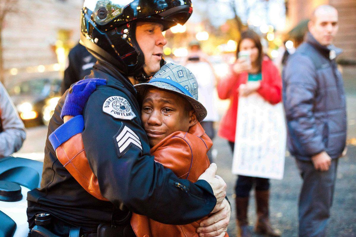 Portland police Sgt. Bret Barnum, left, and Devonte Hart, 12, hug at a rally in Portland, Ore., on Nov. 25, 2014. (Johnny Huu Nguyen/AP Photo)