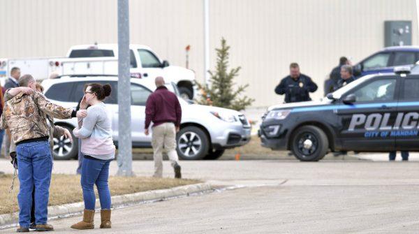 Family and friends console each other at the scene near the south side of the RJR Maintenance and Management building in Mandan, N.D., on April 1, 2019. (Mike McCleary/The Bismarck Tribune via AP)