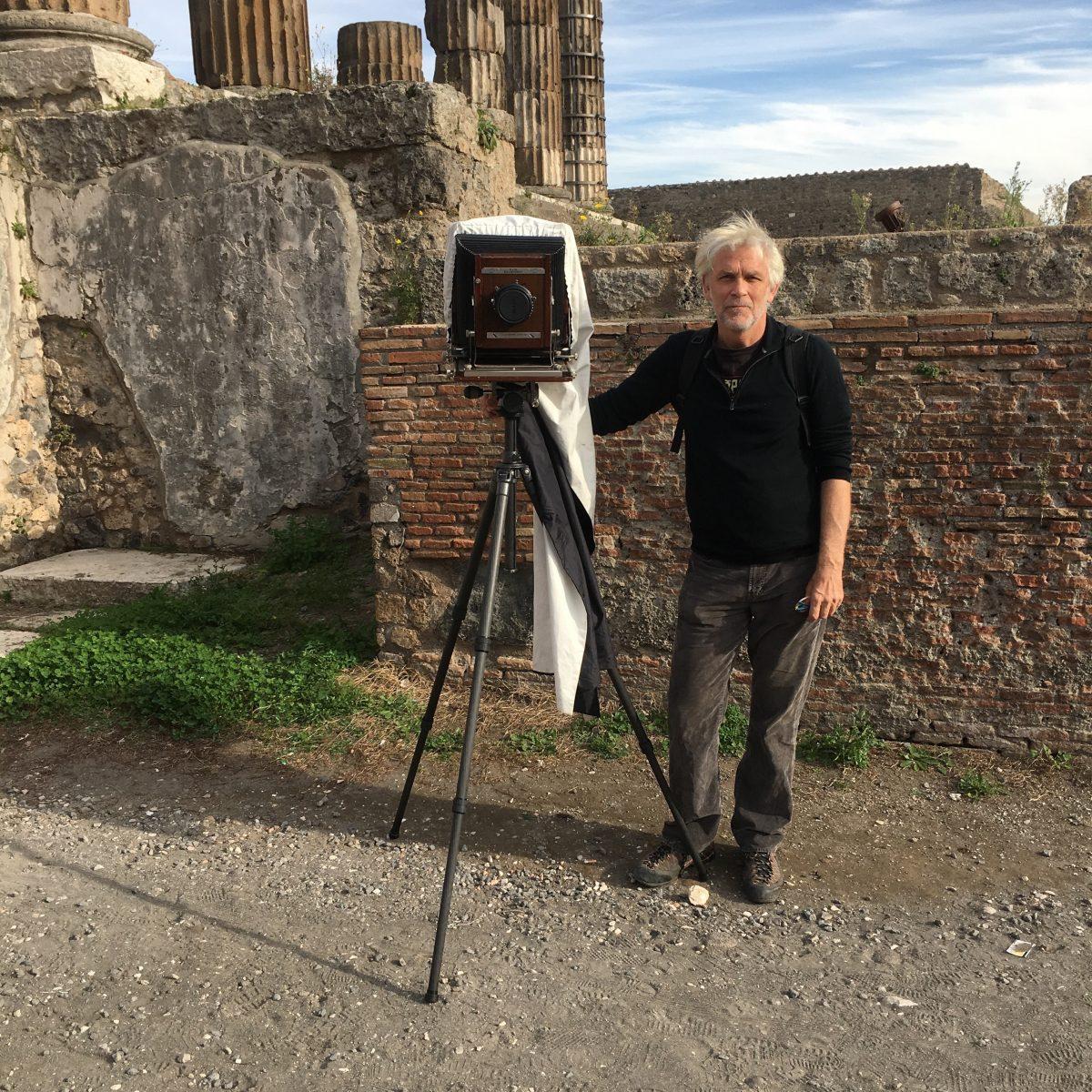 William Wylie in the Forum at Pompeii in 2017, with his Deardorff 8 X 10 inches view camera. This camera is similar to the type of equipment that was used by 19th-century photographers like Giorgio Sommer. The large format negative it produces is capable of great clarity and subtlety. (Grace Hale)