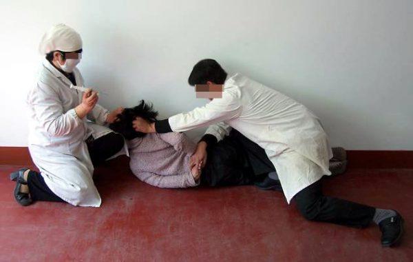 Re-enactment of a healthy woman being forcibly injected with psychiatric drugs. (Minghui.org)