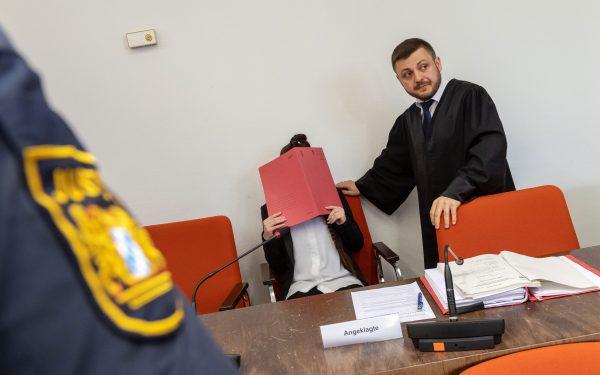 Defendant Jennifer W. (C) hides her face behind a folder and sits next to her lawyer Ali Aydin (R) as she waits in court for the opening of her trial on April 9, 2019, in Munich, southern Germany. The German woman who joined the ISIS is accused of the war crime of letting a 5-year-old Yazidi "slave" girl die of thirst in the sun. (Peter Kneffel/AFP/Getty Images)