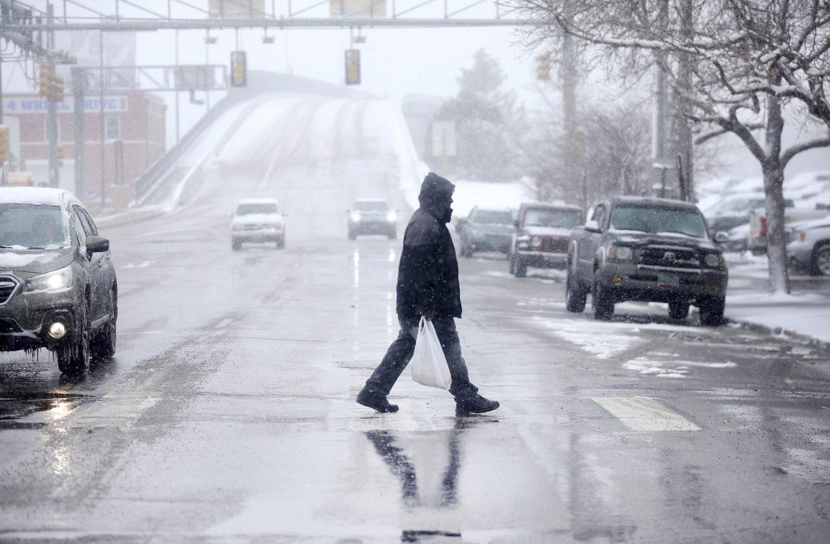 A pedestrian walks across Warren Avenue during a blizzard warning hitting southeast Wyoming and the Colorado Front Range in Cheyenne, Wyo., on April 10, 2019. (Jacob Byk/The Wyoming Tribune Eagle via AP)