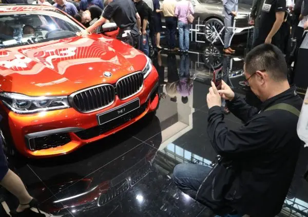 A man takes a photo of a BMW 7 at the Beijing auto show on April 27, 2018. (AFP/Getty Images)