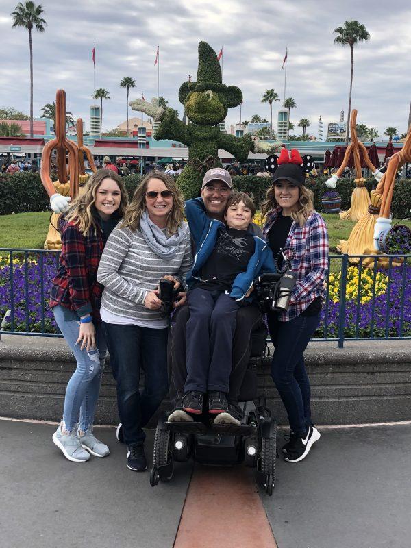 Daughter Sydney (far left), wife Jenielle (left of Jimmy), Jimmy (in wheelchair with son Jake on his lap) and daughter Cassie just a few months ago in Orlando's Disneyworld. (Photo courtesy of Jenielle Ravenna)