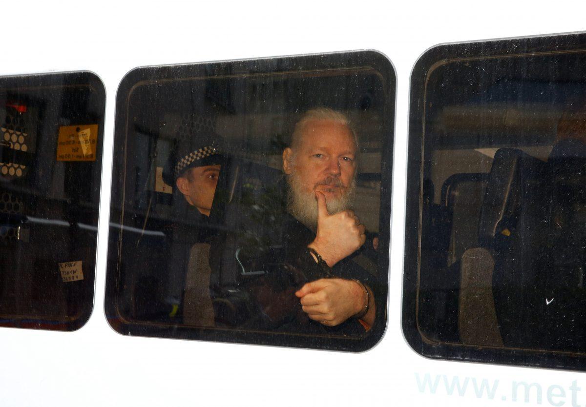 WikiLeaks founder Julian Assange is seen in a police van after was arrested by British police outside the Ecuadorian embassy in London, Britain on April 11, 2019. (Henry Nicholls/Reuters)