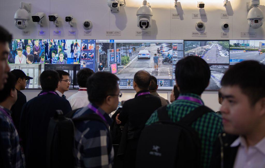 Visitors look at artificial-Intelligence security cameras using facial recognition technology at the 14th China International Exhibition on Public Safety and Security at the China International Exhibition Center in Beijing on Oct. 24, 2018. (Nicolas Asfouri/AFP/Getty Images)