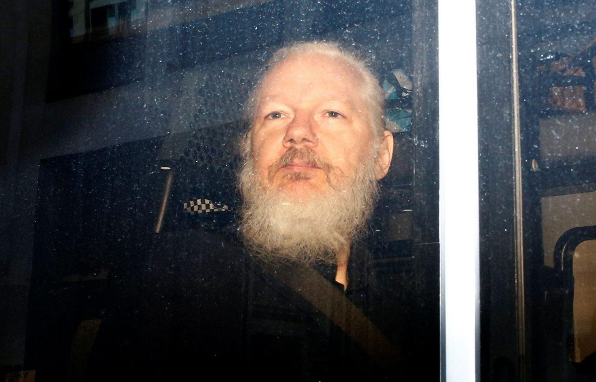 WikiLeaks founder Julian Assange is seen in a police van, after he was arrested by British police, in London on April 11, 2019. (Henry Nicholls/Reuters)