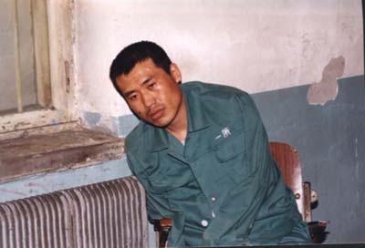 This is the last known photo of Liu Chengjun. Due to torture, he had many injuries and could no longer sit up by himself so had to lean against the wall. (Friends of Falun Gong)