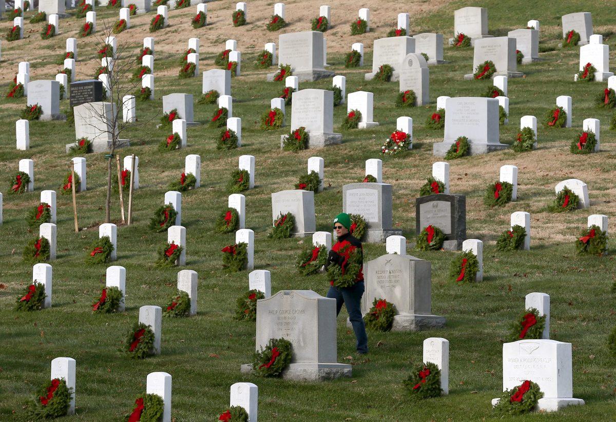 A volunteer looks for a grave to place a wreath on during the National Wreaths Across America Day at Arlington National Cemetery in Arlington, Va., on Dec. 13, 2014. (Mark Wilson/Getty Images)