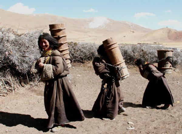 Kangba women carry barrels to fetch water at a village in Zuogong County of Tibet, China on April 10, 2005. (China Photos/Getty Images)