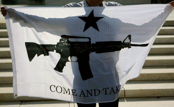 Gun rights activist Ariel Sarousi (L) of Arlington, Virginia holds a banner while standing in front of the U.S. Supreme Court in Washington, on June 26, 2008. (Mark Wilson/Getty Images)