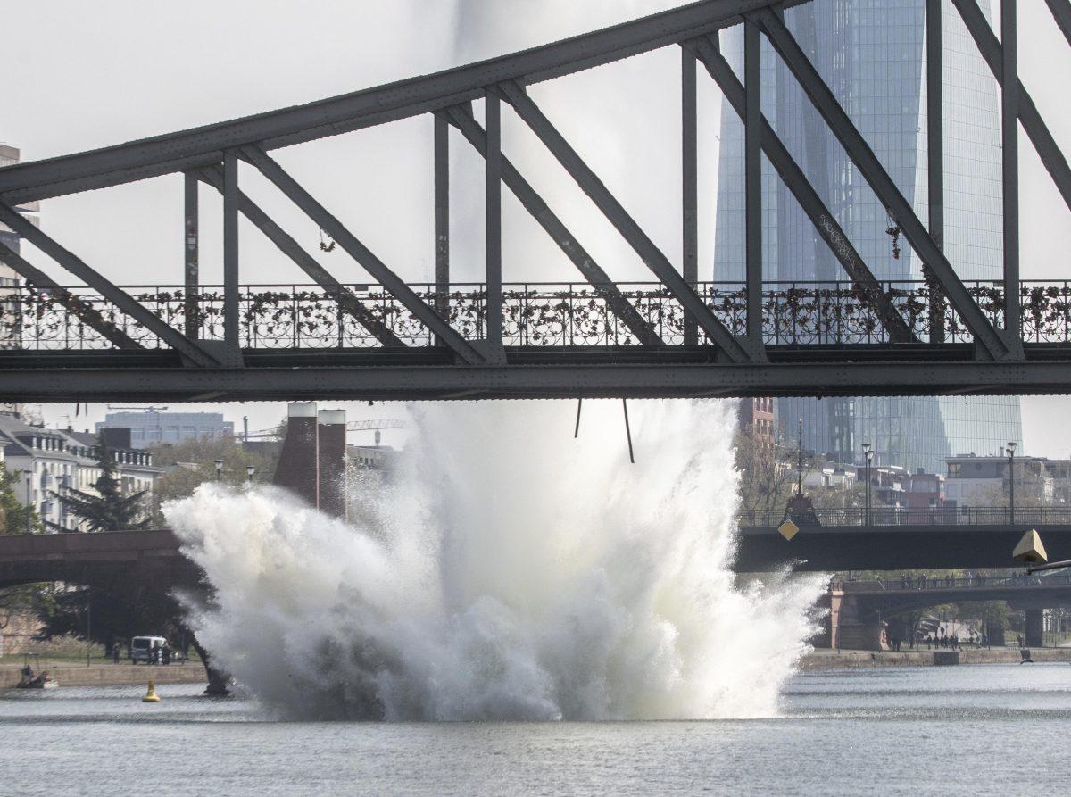 A large water fountain rises behind the Iron Bridge when an American bomb from the Second World War in the Main River is detonated with a blast in Frankfurt, Germany, on April 14, 2019. (Frank Rumpenhorst/dpa via AP)