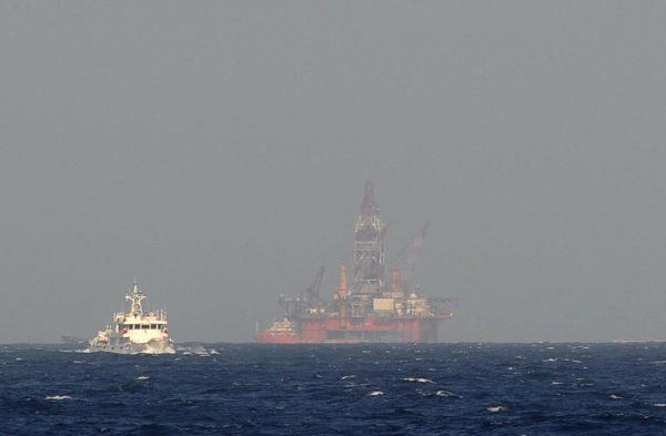 A view from a Vietnamese coast guard ship shows a Chinese coast guard vessel (L) sailing near a Chinese oil drilling rig in disputed waters in the South China Sea, on May 14, 2014. (Hoang Dinh Nam/AFP/Getty Images)