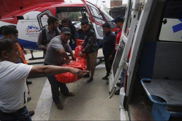 Hospital officials unload the body of a plane crash victim outside the Teaching Hospital in Kathmandu, Nepal, Sunday, April 14, 2019. (Niranjan Shrestha/AP Photo)