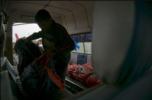 A hospital official loads a body of a plane crash victim into an ambulance outside the Teaching Hospital in Kathmandu, Nepal, Sunday, April 14, 2019. (AP Photo/Niranjan Shrestha)