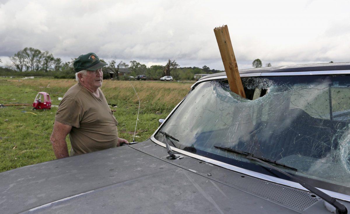A man looks at a piece of wood that was blown through the windshield of his daughters truck in Hamilton, Miss., after a storm moved through the area on April 14, 2019. (Jim Lytle/AP Photo)