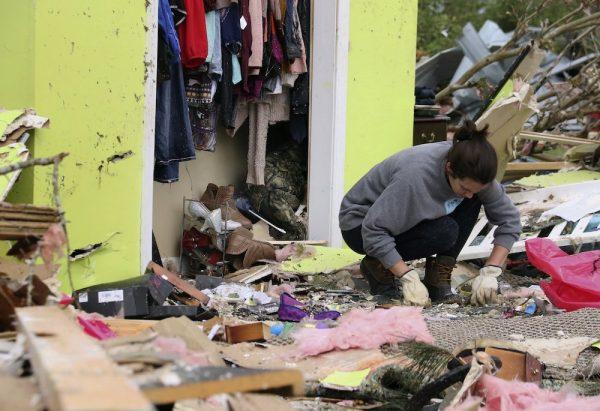 Leslie Harrington kneels down to help a former neighbor and family friend look for jewelry in her destroyed home along Seely Drive outside of Hamilton, Miss., after a deadly storm moved through the area on April 14, 2019. (Jim Lytle/AP Photo)