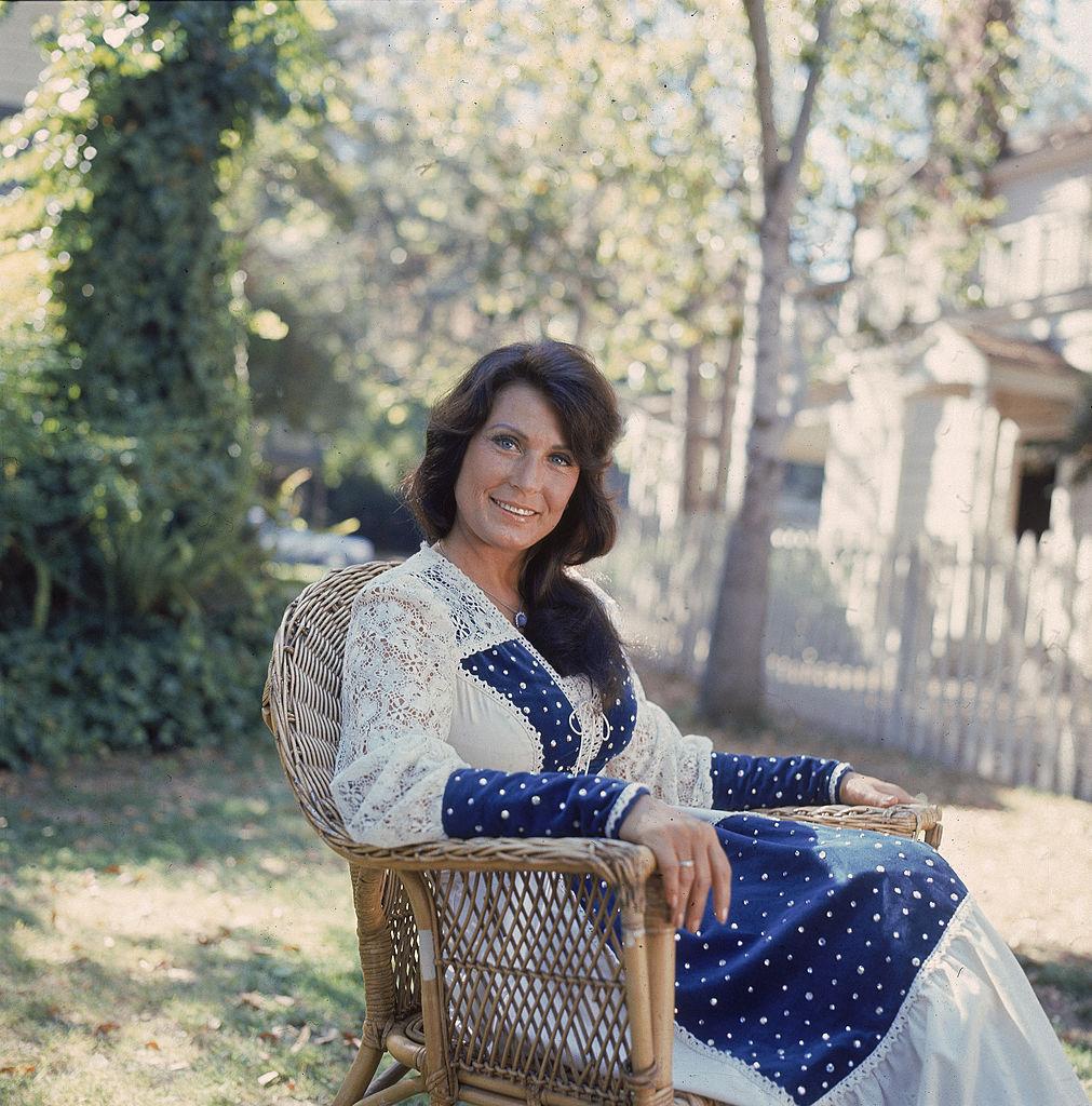 Lynn sits for an outdoor portrait some time in the 1970s (©Getty Images | <a href="https://www.gettyimages.com/detail/news-photo/portrait-of-american-country-music-singer-and-guitarist-news-photo/3130907">Hulton Archive</a>)