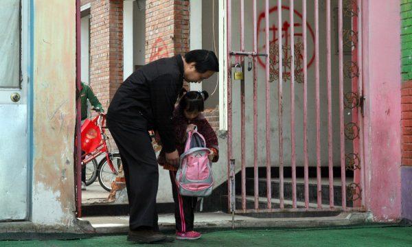 A father picking up his daughter from kindergarten. (STR/AFP/GettyImages)