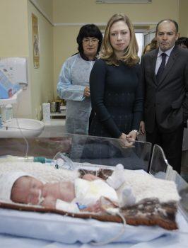 Chelsea Clinton (C), daughter of former President Bill Clinton, and Ukrainian businessman and philanthropist Victor Pinchuk (R) look at a 3-week-old baby in a neonatal care unit at the National Children's Hospital in Kiev on Jan. 24, 2012. (Efrem Lukatsky/AFP/Getty Images)