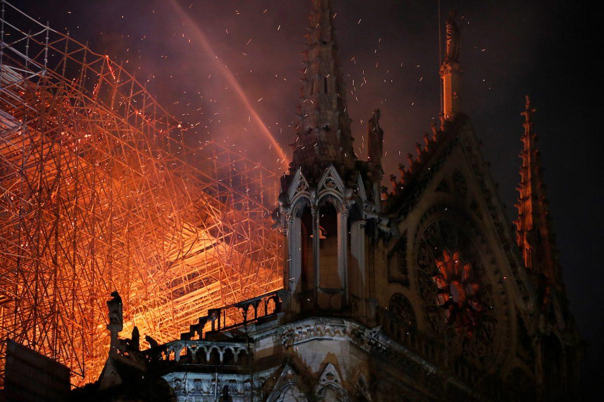 Sparks fill the air as Paris Fire brigade members spray water to extinguish flames as the Notre Dame Cathedral burns in Paris, France, on April 15, 2019. (Philippe Wojazer/Reuters)