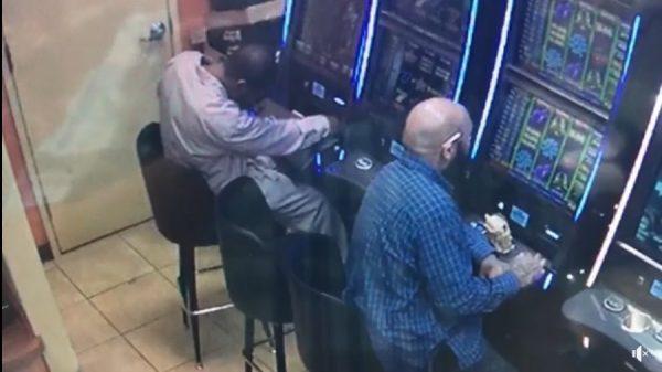 The suspect reaches into the machine and moments later allegedly takes out cash. (Crime Stoppers Greater Atlanta)