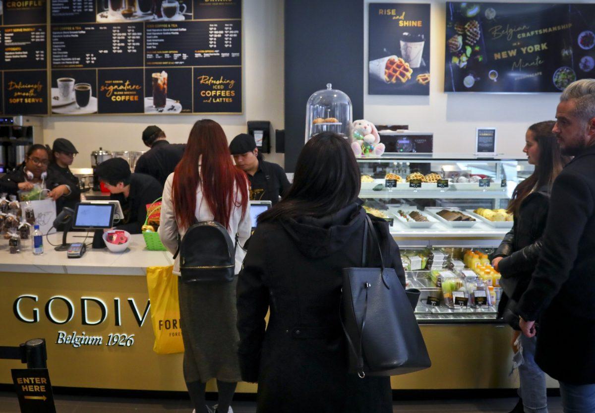 Customers wait in line for service at Godiva's new cafe in N.Y., on April 16, 2019. (Bebeto Matthews/AP)