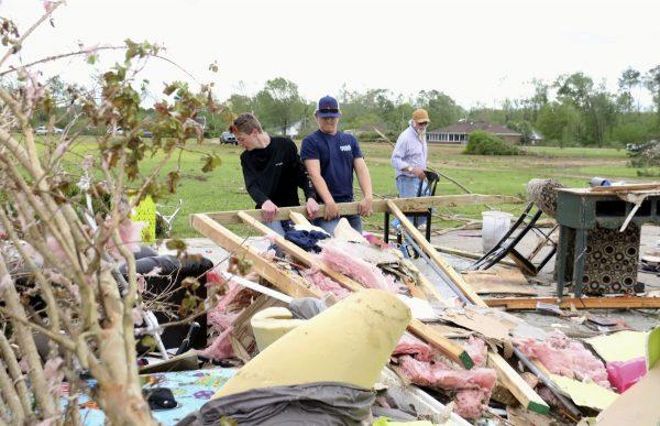Men clean up house debris at Hamilton, Mississippi, on April 14, 2019. (AP Photo/Jim Lytle)