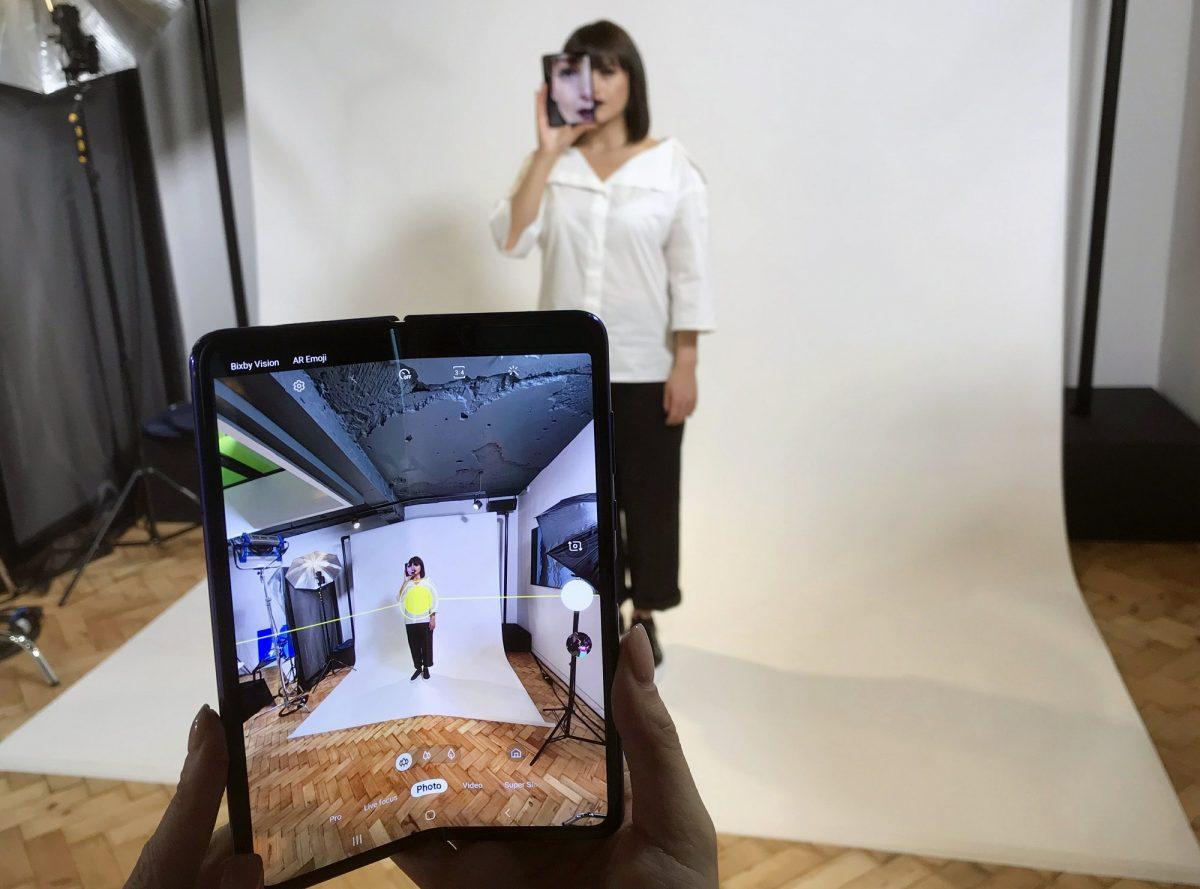 A model holds a Samsung Galaxy Fold smartphone to her face, during a media preview event in London, on April 16, 2019. (Kelvin Chan/AP Photo)