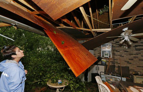Sonya Banes looks at damage caused by a large oak tree that crashed through the ceiling of her mother's house in Learned, Miss., on April 18, 2019. (Rogelio V. Solis/Photo via AP)