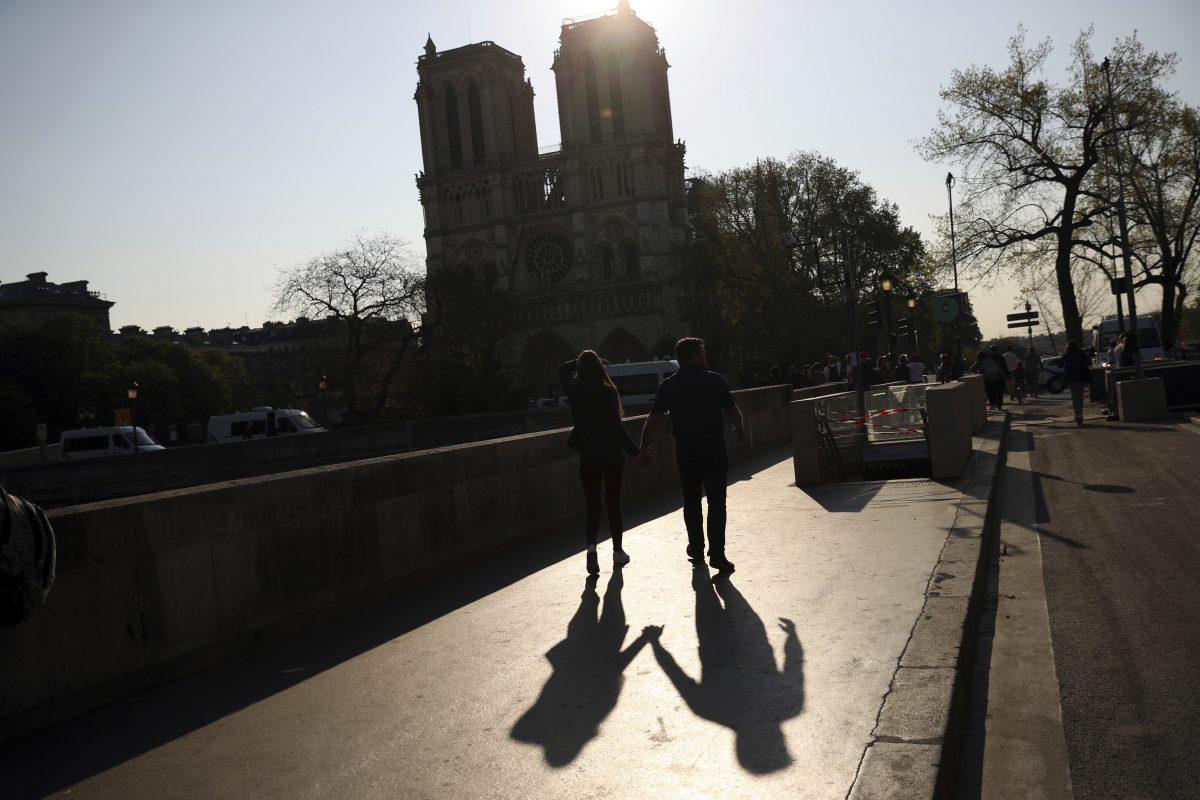 Two people walk by a closed metro station near the Notre Dame Cathedral in Paris, on April 20, 2019. (Francisco Seco/AP Photo)