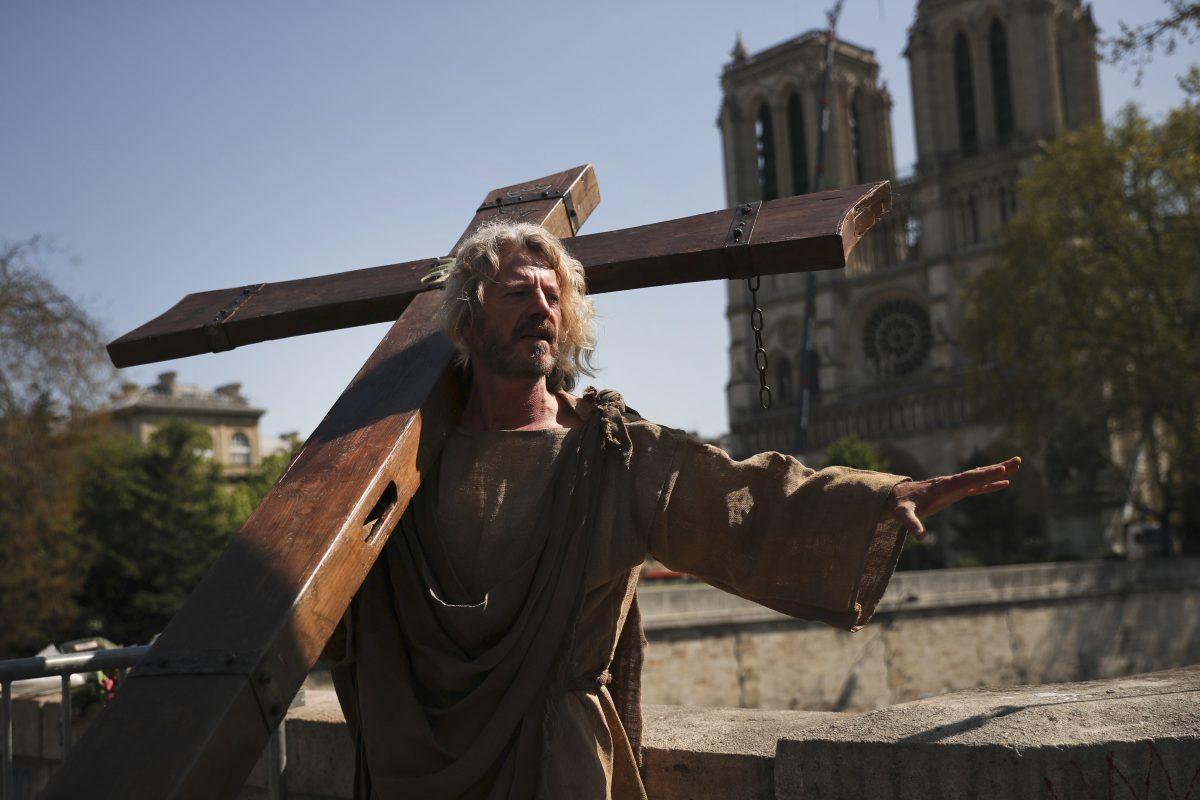 A man carries a wooden cross outside the Notre Dame Cathedral as part of a demonstration in Paris, Saturday, on April 20, 2019. (Francisco Seco/AP Photo)
