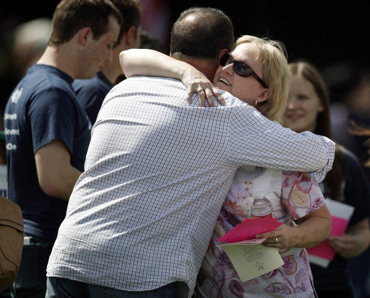 Attendees hug before a program for the victims of the massacre at Columbine High School 20 years ago, in Littleton, Colo., on April 20, 2019. (David Zalubowski/AP Photo)