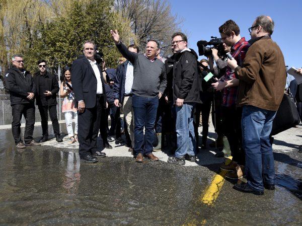 Quebec Premier Francois Legault speaks to Gatineau Mayor Maxime Pedneaud-Jobin at the edge of floodwaters on Rue Saint-Louis in Gatineau, Que., on April 22, 2019. (The Canadian Press/Justin Tang)