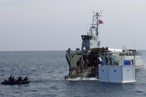 A Royal Thai Navy ship drags a floating home, lived in by a U.S. man and his Thai partner, in the Andaman Sea, off Phuket Island in Thailand, April 22, 2019. (Stringer/Reuters)