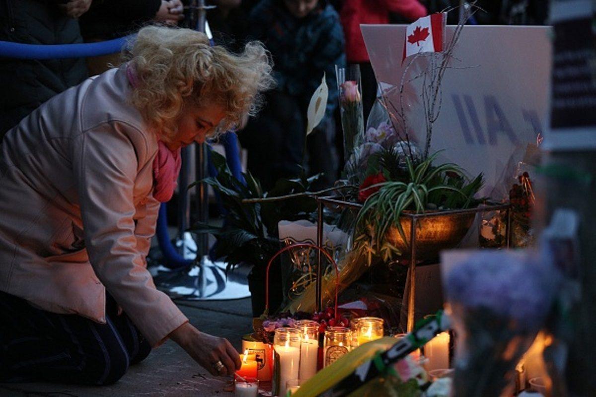 A woman light candles at a makeshift memorial in Mel Lastman Square in Toronto for the victims of the van attack before a vigil on April 29, 2018. (Lars Hagberg/AFP/Getty Images)