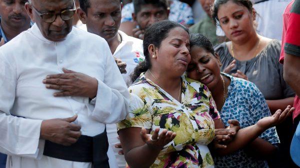 People react during a mass burial of the victims, two days after a string of suicide bomb attacks on churches and luxury hotels across the island on Easter Sunday, in Colombo, Sri Lanka, on April 23, 2019. (Dinuka Liyanawatte/Reuters)