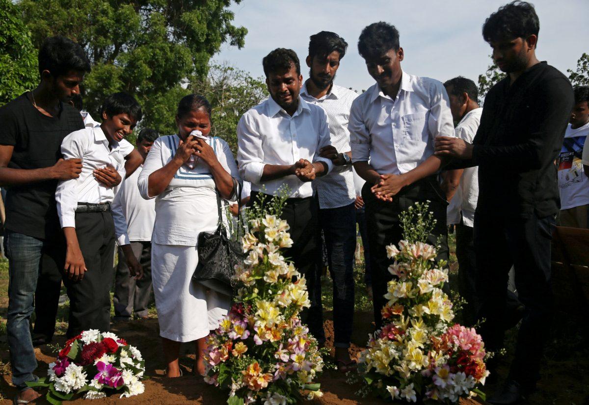 People react during a mass burial of victims, two days after a string of suicide bomb attacks on churches and luxury hotels across the island on Easter Sunday, at a cemetery near St. Sebastian Church in Negombo, Sri Lanka, on April 23, 2019. (Athit Perawongmetha/Reuters)