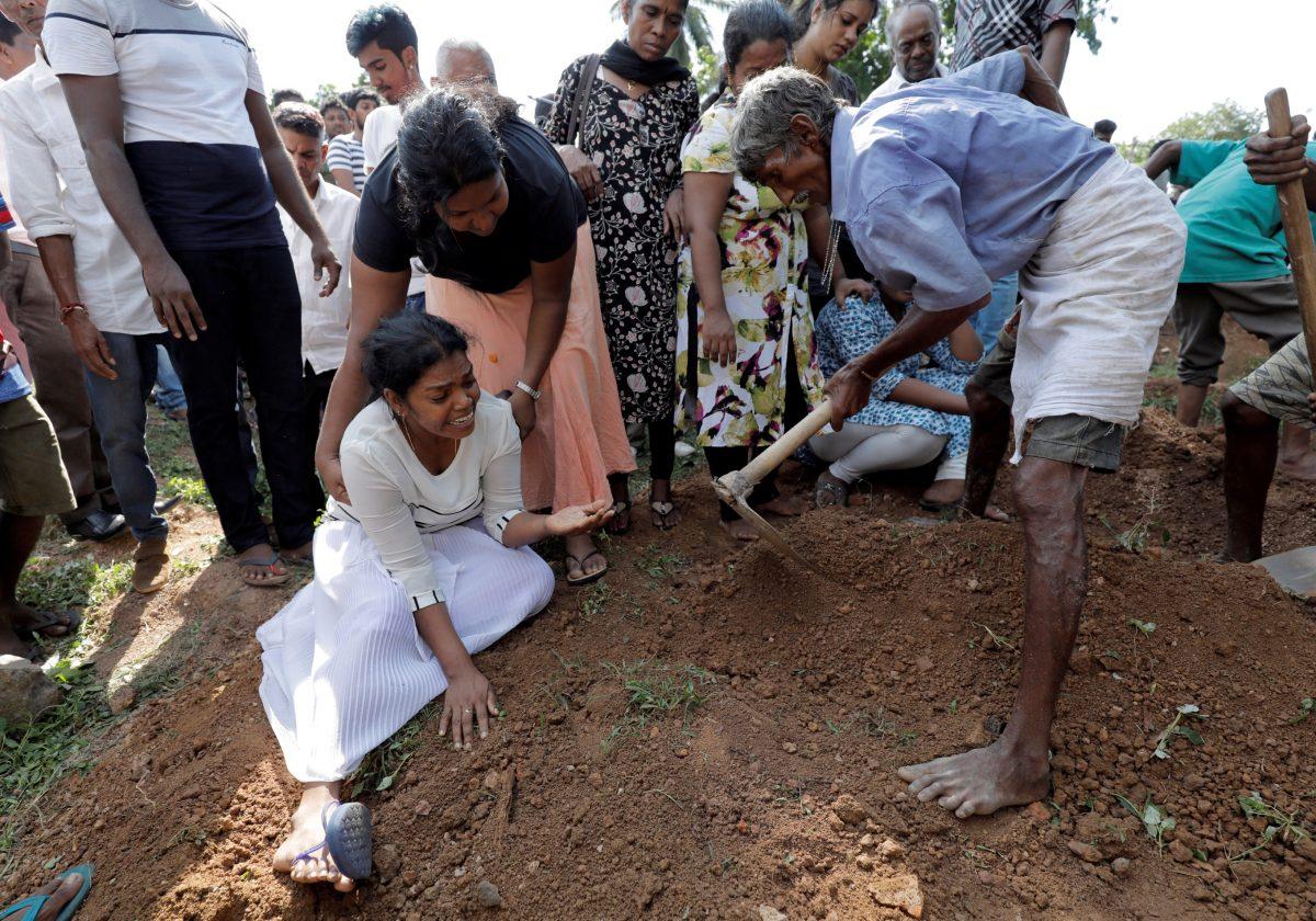 A woman reacts during a mass burial of victims, two days after a string of suicide bomb attacks on churches and luxury hotels across the island on Easter Sunday, in Colombo, Sri Lanka, on April 23, 2019. (Dinuka Liyanawatte/Reuters)