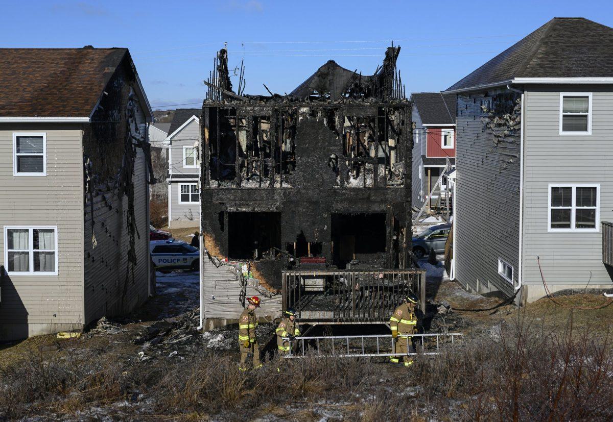 Firefighters investigate following a house fire in the Spryfield community in Halifax, Canada, on Feb. 19, 2019. (Darren Calabrese/The Canadian Press via AP)