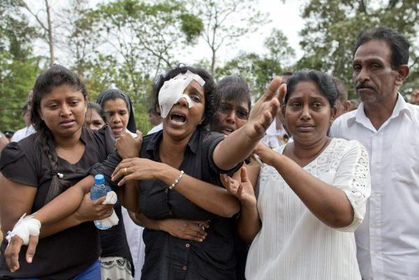 Anusha Kumari, center, weeps during a mass burial for her husband, two children and three siblings, all victims of Easter Sunday's bomb attacks, in Negombo, Sri Lanka, on April 24, 2019. (Gemunu Amarasinghe/AP Photo)