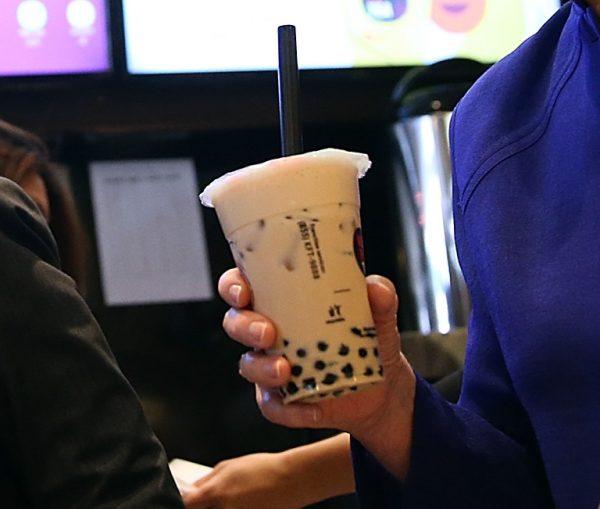 A woman holding a cup of milk tea, also called bubble tea. (Justin Sullivan/Getty Images)