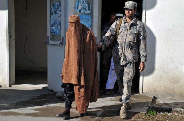 Afghan border police present a burqa-clad Taliban fighter to the Afghanistan Border Police headquarters in Jalalabad, Nangarhar province, on Feb. 7, 2013. (Noorullah Shirzada/AFP/Getty Images)