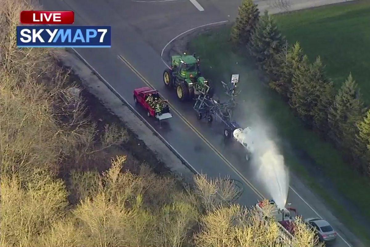 A fire engine sprays water on a container of the chemical that farmers use for soil after after anhydrous ammonia leaked in Beach Park, Ill., on April 25, 2019. (ABC7 Chicago via AP)