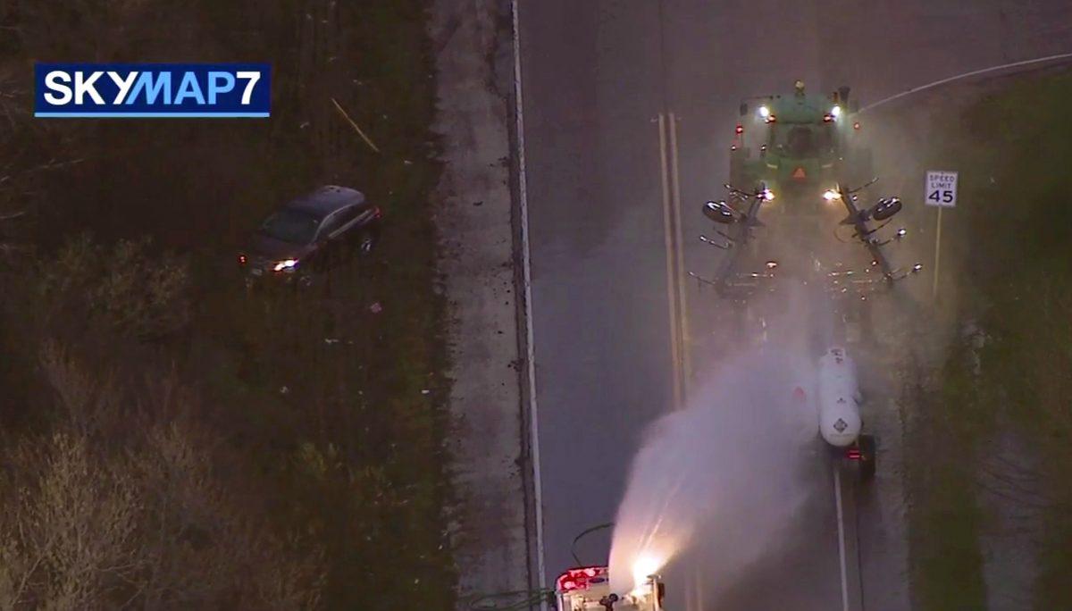 A fire engine sprays water on a container of a chemical that farmers use for soil after anhydrous ammonia leaked in Beach Park, Ill., on April 25, 2019. (ABC7 Chicago via AP)