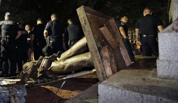Police stand guard after the Confederate statue known as Silent Sam was toppled by protesters on campus at the University of North Carolina in Chapel Hill, N.C., on Aug.20, 2018. (Gerry Broome, AP Photo/File)
