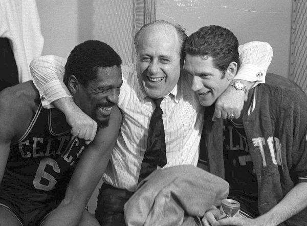 Boston Celtics general manager Red Auerbach hugs Bill Russell, left, and John Havlicek, right, in L.A., on May 3, 1968. (File photo/AP)