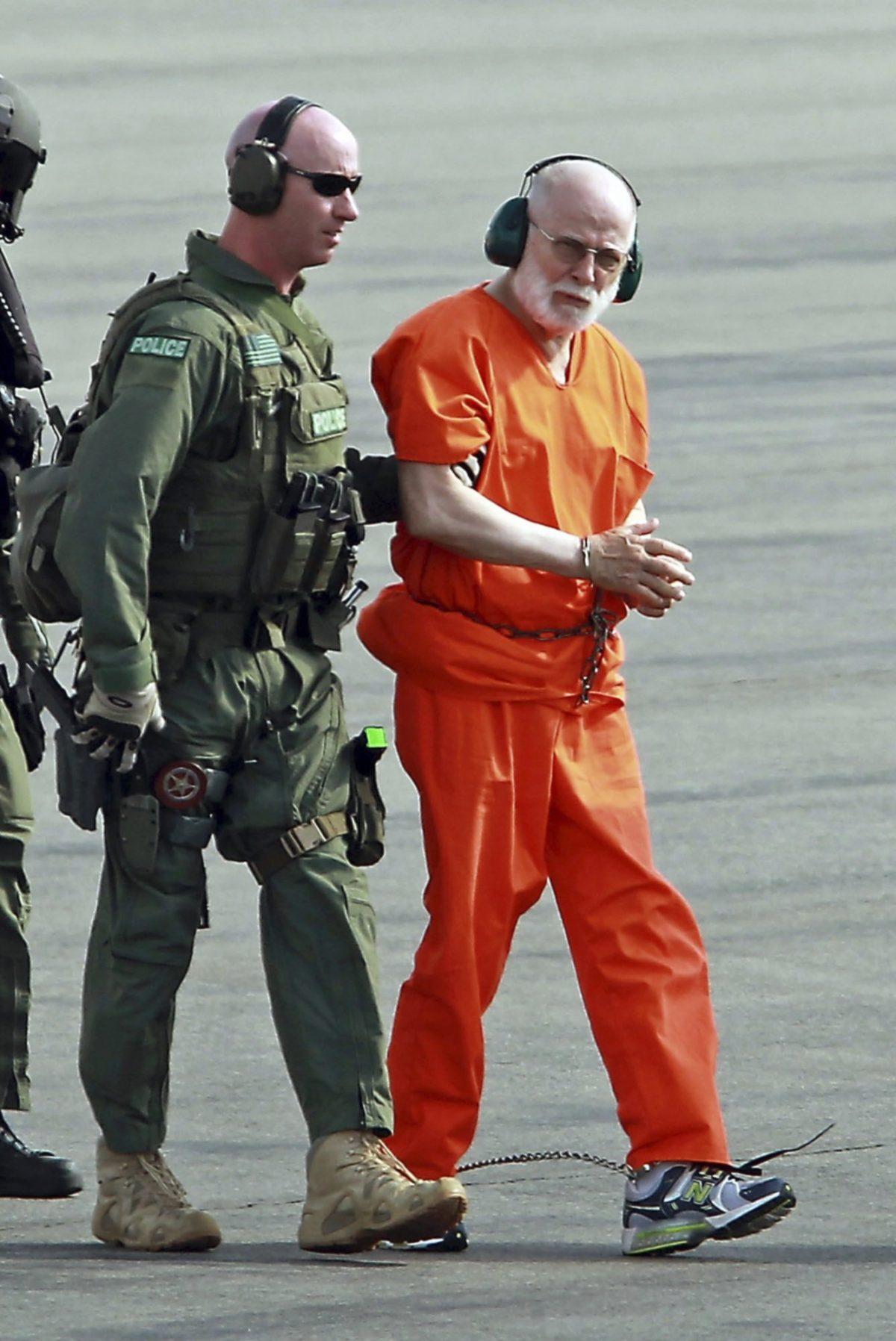 James "Whitey" Bulger, right, is escorted from a U.S. Coast Guard helicopter to a waiting vehicle at an airport in Plymouth, Mass., after attending hearings in federal court in Boston, on June 30, 2011. (Stuart Cahill/The Boston Herald via AP, File)