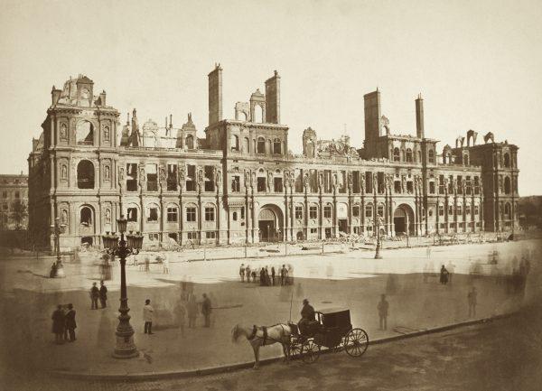 Passersby look at the remains of the Hotel de Ville after communists burned it during the Paris Commune of 1871. (Public Domain)