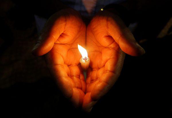A man holds a candle during a vigil to show solidarity with the victims of Sri Lanka's serial bomb blasts, inside a college in Kolkata, India, on April 26, 2019. (Rupak De Chowdhuri/Reuters)